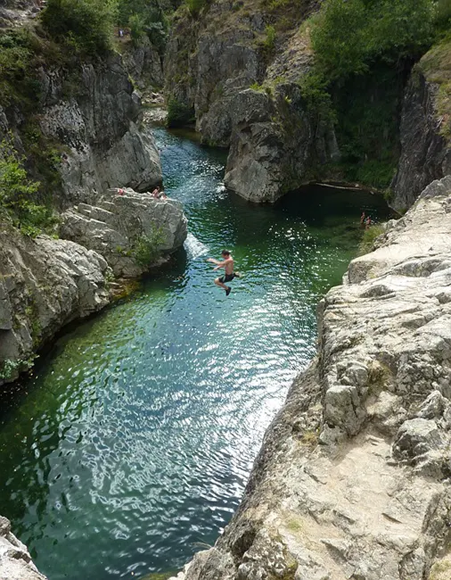 Un enfant saute dans la rivière Ardèche
