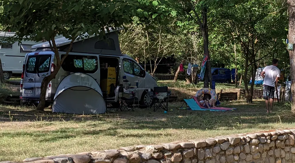Un van aménagé bien installé sur la place de camping